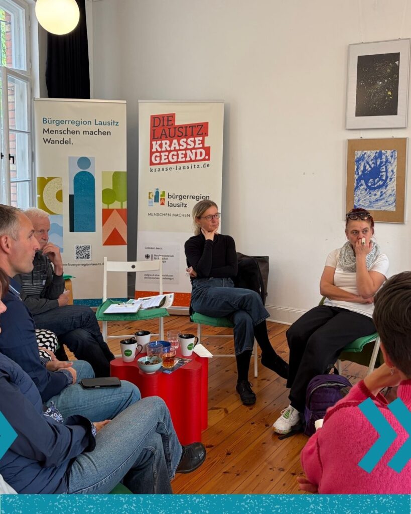Menschen beim Fest für Engagement und Beteiligung sitzen zusammen in der MitMachWerkstatt.